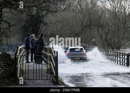 Lacock, Wiltshire, UK. 1st Jan, 2024. The River Avon in Lacock has burst its banks on flooded the road out of the village. Advice is not to drive through flood water but the road is passable with caution. Credit: JMF News/Alamy Live News Stock Photo