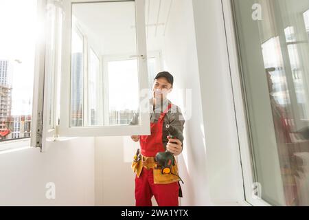 Carpenter repairing window frames, home is being updated to be sold Stock Photo