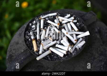 An ashtray for cigarette butts on the street. Smoked cigarettes in the trash. Stock Photo