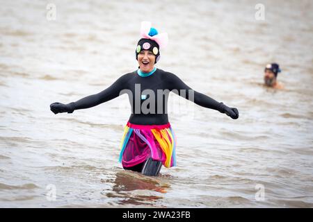 Haltern Am See, Germany. 01st Jan, 2024. A disguised swimmer stands in the cold water. 590 participants take part in the New Year's Swim 2024, a new record. Credit: Christoph Reichwein/dpa/Alamy Live News Stock Photo