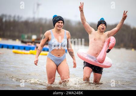 Haltern Am See, Germany. 01st Jan, 2024. Two participants cheer in the ice-cold water. 590 participants take part in the New Year's Swim 2024, a new record. Credit: Christoph Reichwein/dpa/Alamy Live News Stock Photo