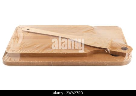 Polyethylene-wrapped kitchen wooden set of cutting boards and kitchen spatula. White background, copy space. Stock Photo