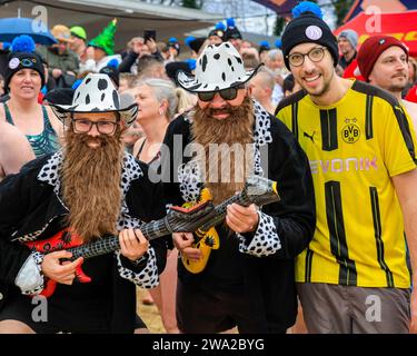 Haltern, Germany. 01st Jan, 2024. 'ZZ Top' at the start line. A record 590 registered swimmers, the highest number in many years, plus visitors, have fun at the annual New Year's Day swim, an open water swimming event which takes place at Haltern Lake in the town of Haltern, North Rhine Westphalia. Despite unpredictable weather with rain, many brave the run along the beach and into the cold lake in costumes to celebrate the new year in style. All proceeds of the event go to local charities. Credit: Imageplotter/Alamy Live News Stock Photo