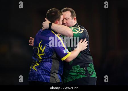 Luke Littler celebrates victory over Brendan Dolan (right) on day fourteen of the Paddy Power World Darts Championship at Alexandra Palace, London. Picture date: Monday January 1, 2024. Stock Photo