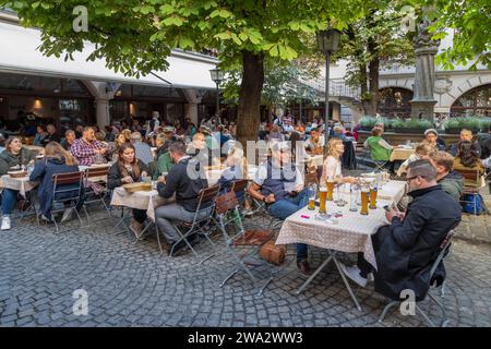 Locals and tourists enjoy the beer in the Biergarten (beer garden) in the Hofbräuhaus in the center of Munich, Bavaria, Germany. Stock Photo