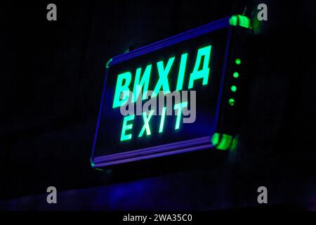 Image of a glowing exit sign above the doors in the hall Stock Photo
