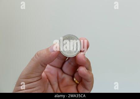 swiss five franc coin between fingers - swiss franc coin Stock Photo