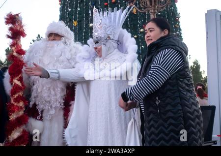 New Year celebrationsat Kuk saroy square Samarkand Uzbekistan. Father frost- Santa Claus and Snegurochka, snow lady, costumes taking picture Stock Photo