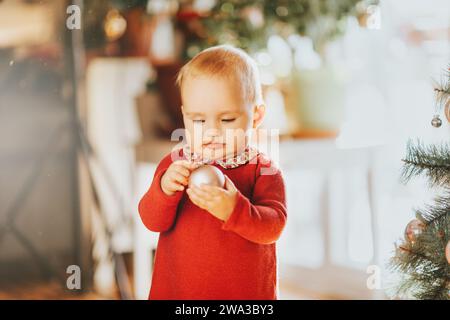 Adorable 1 year old baby girl enjoying Christmas at home Stock Photo