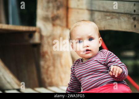 Outdoor portrait of adorable baby girl having fun on playground Stock Photo