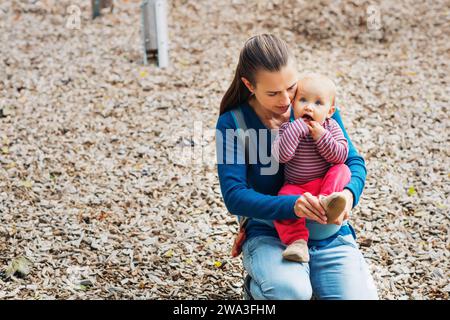 Mother putting shoes on baby girl Stock Photo