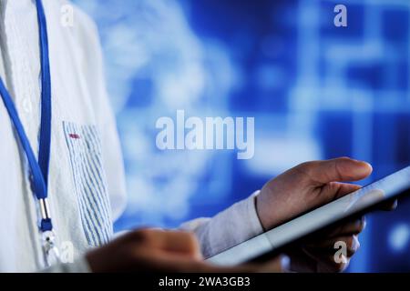 Tech support writes code on tablet to visualize artificial intelligence neural networks using augmented reality, close up. Data center facility worker runs AI script for information processing Stock Photo