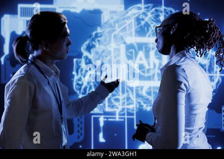Coworkers brainstorming ways to use AI cognitive computing to extract usable information from complex data. Colleagues implementing artificial intelligence to process massive datasets Stock Photo