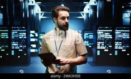 Engineer walking through data center providing computing resources needed for artificial intelligence to process massive datasets for training. Server room storing data used for machine learning Stock Photo