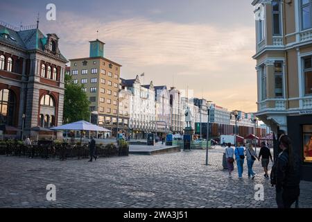 Bergen, Norway, June 23, 2023: People walk the Vågsallmenningen town square, made of cobblestone during the sunset hour. The commons is located near t Stock Photo
