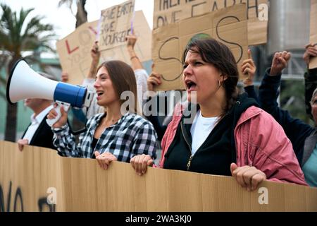 Angry and rebellious woman speaking and protesting with megaphone at demonstration at climate change Stock Photo