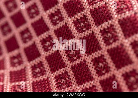 draped woven double cloth in red and pink geometric, diamond grid pattern, close up macro detail shot with shallow depth of field Stock Photo