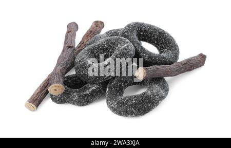 Many tasty candies and dried sticks of liquorice root isolated on white Stock Photo