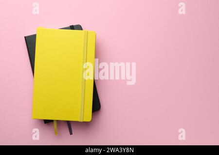 Different notebooks on light pink background, top view. Space for text Stock Photo