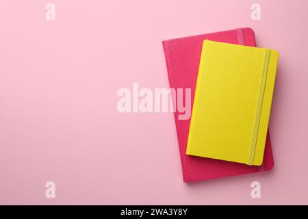 Different notebooks on light pink background, top view. Space for text Stock Photo