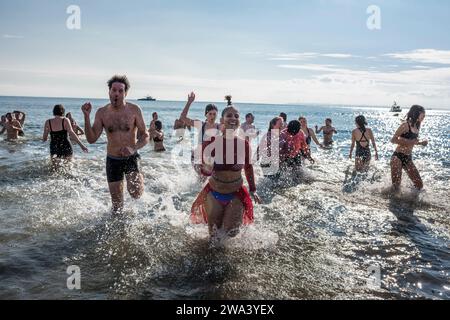 Brooklyn, New York - January 1, 2024: Group running out of the ocean, Coney Island Polar Bear New Years Day Plunge. Stock Photo