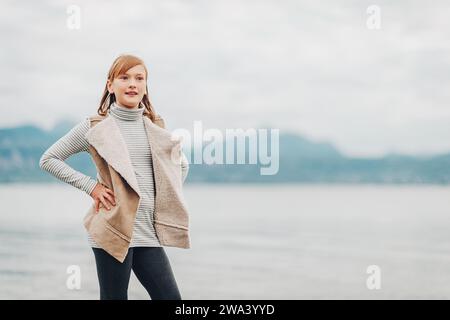 Outdoor portrait of pretty little girl resting by the lake on a cloudy day, image taken in Lausanne, Switzerland Stock Photo