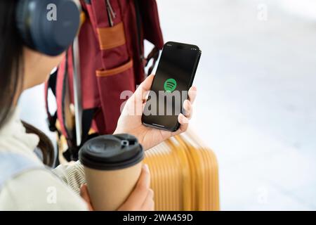 CHIANG MAI, THAILAND - DECEMBER 20, 2023: Person holding a brand new Apple iPhone 14 Pro with Spotify logo on the screen. Spotify is a popular Stock Photo