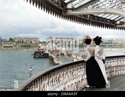 1899  ca. , CLACTON ON SEA , ESSEX  , GREAT BRITAIN  : The pier and the beach in BELLE EPOQUE time . Clacton-on-Sea is the largest town on the Tendring peninsula, in Essex, ENGLAND and was founded in 1871 . Photo by Anonymous . DIGITALLY COLORIZED . -  GRAND BRETAGNA  - VIEW -  ITALIA - FOTO STORICHE - HISTORY - ART NOUVEAU - GEOGRAFIA - GEOGRAPHY  - ARCHITETTURA - ARCHITECTURE  - PANORAMA -  sea - mare - villeggiatura - turisti - tourists - turismo - tourism - passeggiata - promenade  - pier - gente - people Stock Photo
