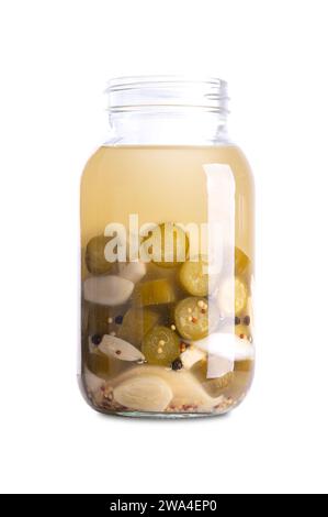 Garlic cucumbers, homemade and fermented in a glass jar. Sliced cucumbers and garlic cloves fermented by lactic acid bacteria. Stock Photo