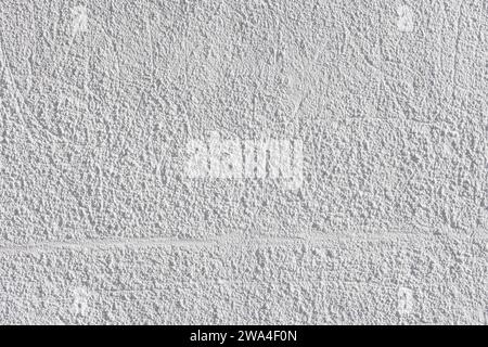 rough whitewash or white plaster wall under direct sunlight, full-frame background and texture Stock Photo