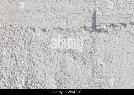 rough whitewash or white plaster wall under direct sunlight, full-frame background and texture Stock Photo