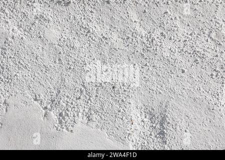 rough whitewash or white plaster wall under direct sunlight, full-frame background and texture Stock Photo