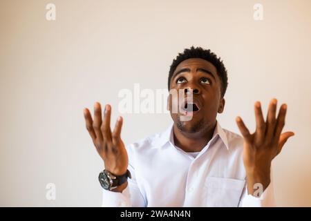 Portrait of young businessman who is disappointed and anxious. He is praying. Stock Photo