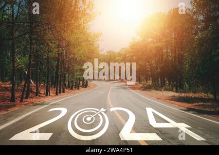 2024 written on the road. New year 2024. Business achievement goal and objective target, challenge, goal. Asphalt road with at sunset. Stock Photo