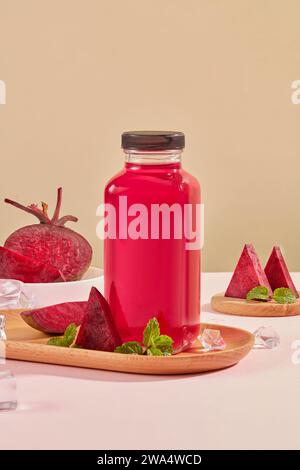 Fresh beetroot slices decorated with glass bottle unlabeled containing beetroot juice on wooden dishes on brown background. Beet juice may help lower Stock Photo