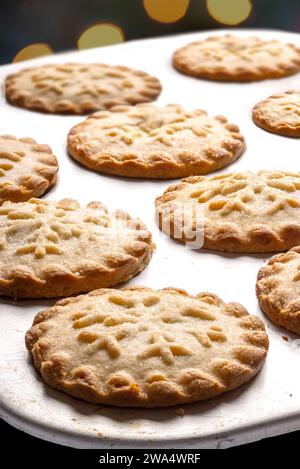 Traditional british mince pies on a baking tray with Christmas lights in the background Stock Photo
