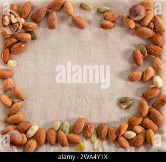 Almonds, walnuts, hazelnut and pumpkin seeds on the burlap background. Top view. Stock Photo