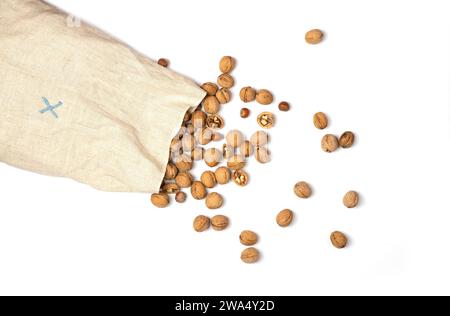 Large bag of burlap with walnuts and hazelnuts. Nuts scattered on a white background. Top view. Isolated on white. Stock Photo