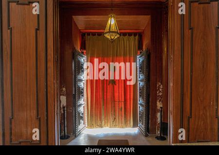 catholic church door with sunlight coming through red curtain Stock Photo
