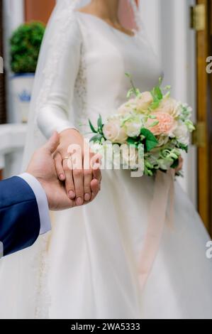 Crop newlyweds holding hands during wedding Stock Photo