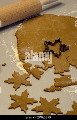 Cut out star cookies from rolled out dough before baking Stock Photo