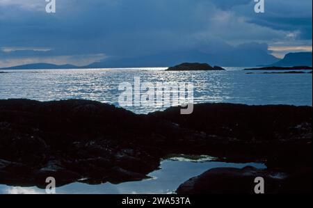 Storm clouds over the Isle of Eigg viewed from the beach at Arisaig Lochaber Scotland Stock Photo