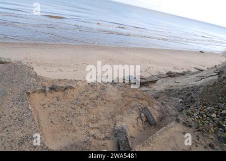 Broken edge of Access Road that collapsed due to coastal erosion, on The Marrams, looking down at Beach and sea below. Stock Photo