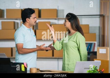 Two business partners or coworkers arguing each other at warehouse or office workplace - concept of misunderstanding, coordination problems and Stock Photo