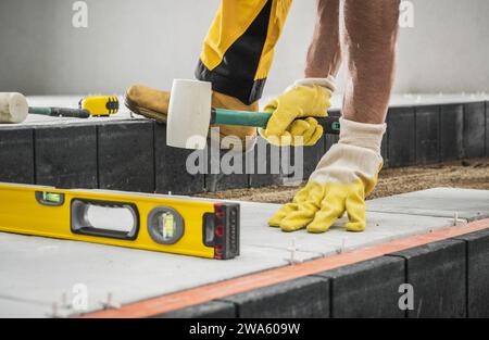 Concrete Bricks Patio Building by Professional Caucasian Construction Worker Stock Photo