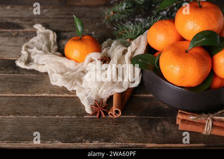 Bowl with tasty tangerines and cinnamon on wooden table, closeup Stock Photo