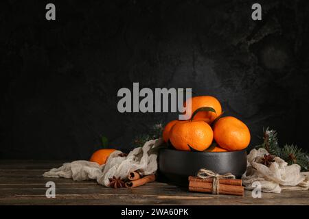 Bowl with tasty tangerines and cinnamon on wooden table Stock Photo
