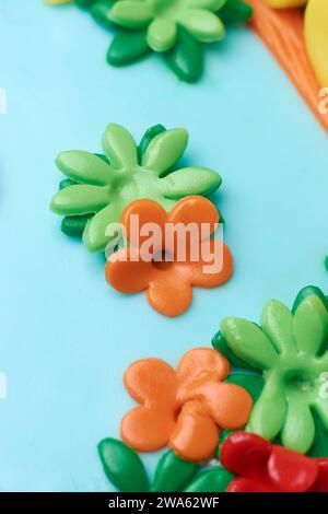 close-up of kids birthday cake icing flowers, edible decorations in delightful touch for celebration on light blue cake surface, selective focus Stock Photo