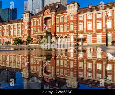 Beautiful reflection of the red brick Tokyo Station in water sprayed to cool the path in the middle of summer Stock Photo
