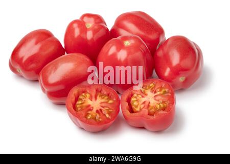 Heap of fresh whole and halved heirloom juicy tomatoes isolated on white background close up Stock Photo